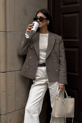 a lady wears a camel wool blazer with white T-shirt and jeans